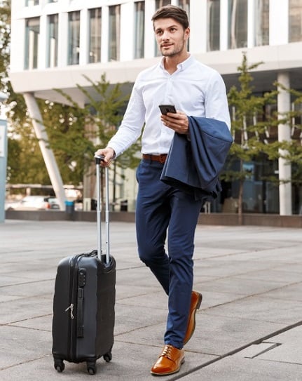 Traveling. Wearing white, V neck T shirt, blue pants, brown boot shoes, a  hand carrying duffel bag, a young black college student is sitting on dock  b Stock Photo - Alamy